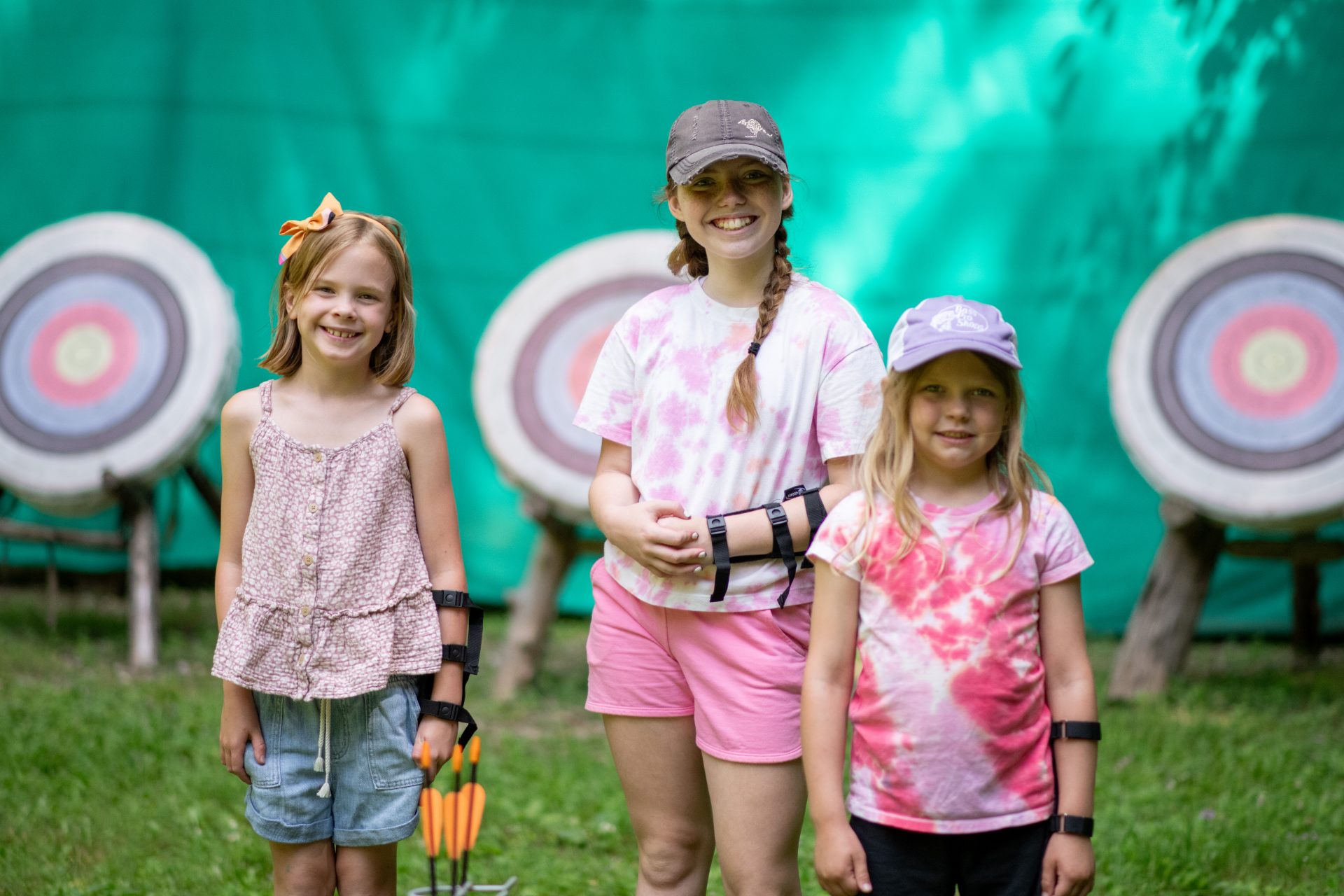 3 girls standing in front of archery targets